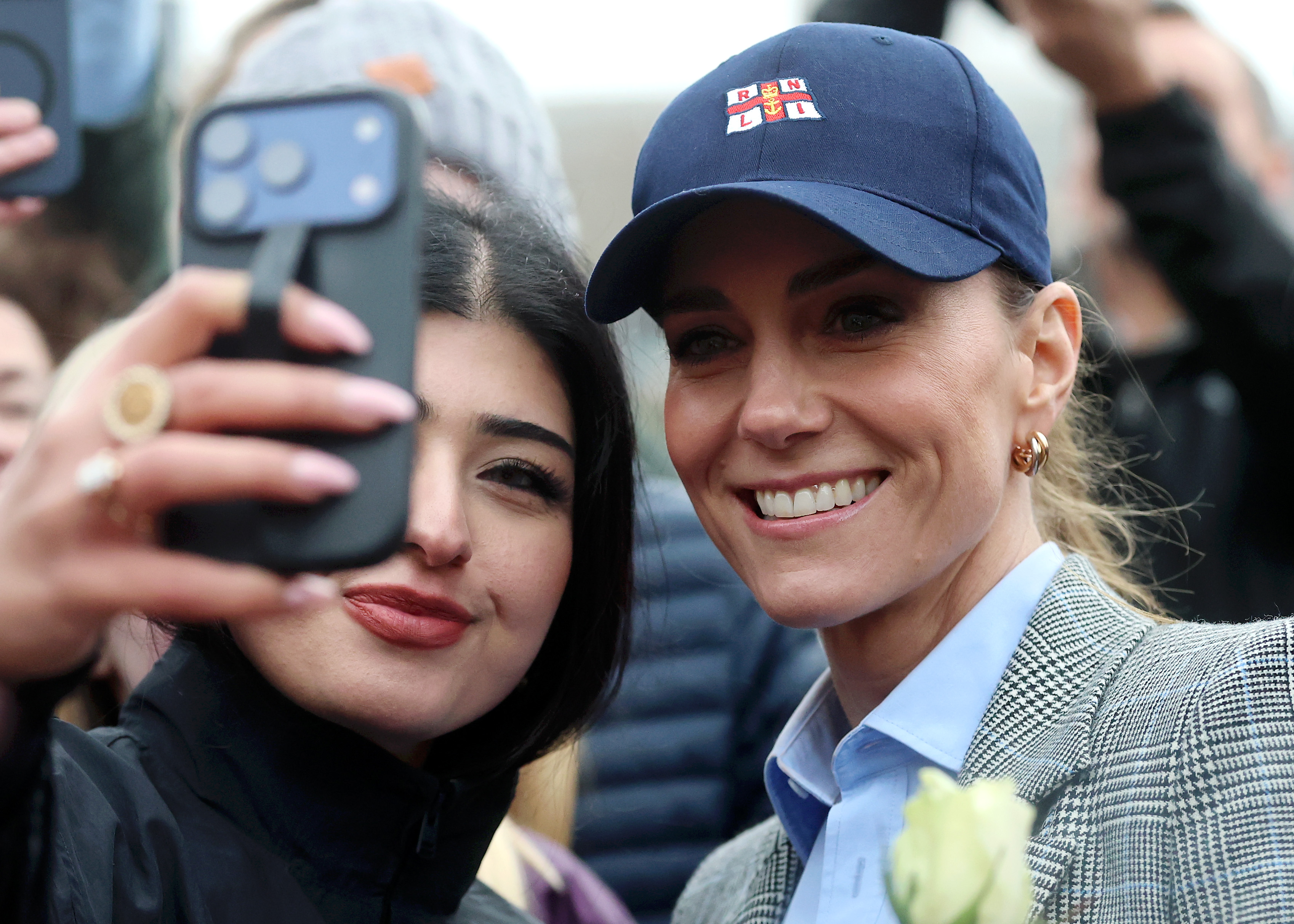 Princess Kate wearing a baseball hat taking a selfie with a woman