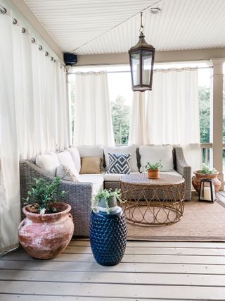 Bright airy sunroom with wicker furniture, sheer drapes and cushions