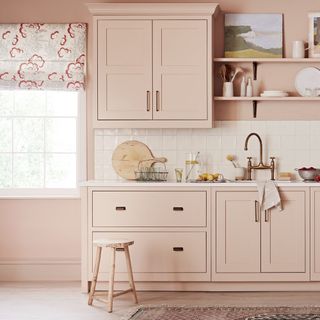 Pale pink kitchen cabinets with white tile splashback