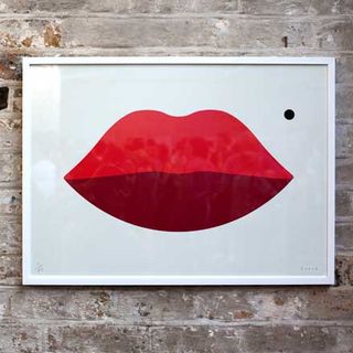 The print has red lips on a white background and a black mole above the lips.