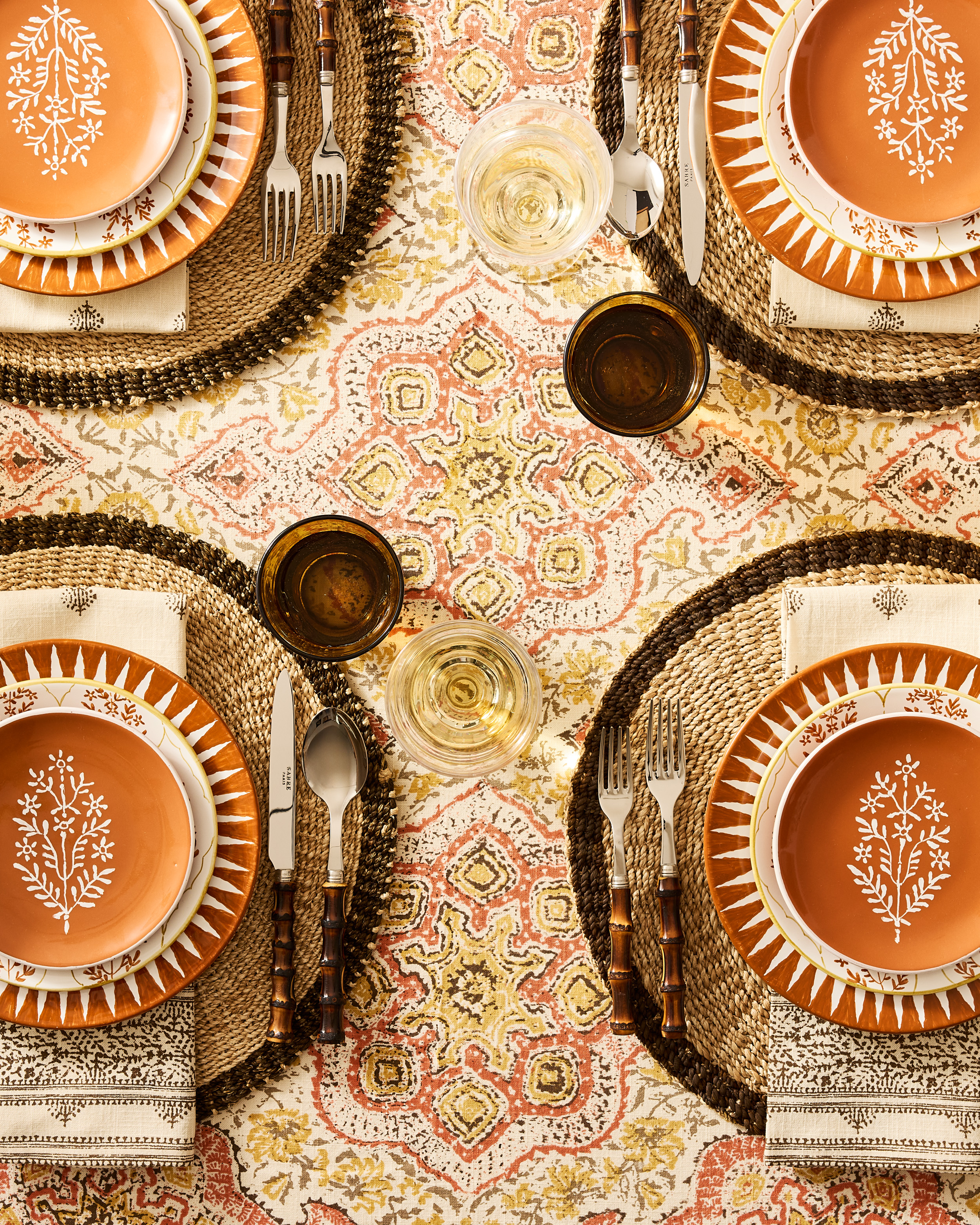 Rust colored plates on a patterned tablecloth