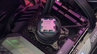 Фотография процессора AMD Ryzen 9 9900X, установленного на охлаждающем устройстве ЦП на материнской плате.