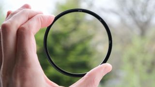 UV lens filter held between two fingers