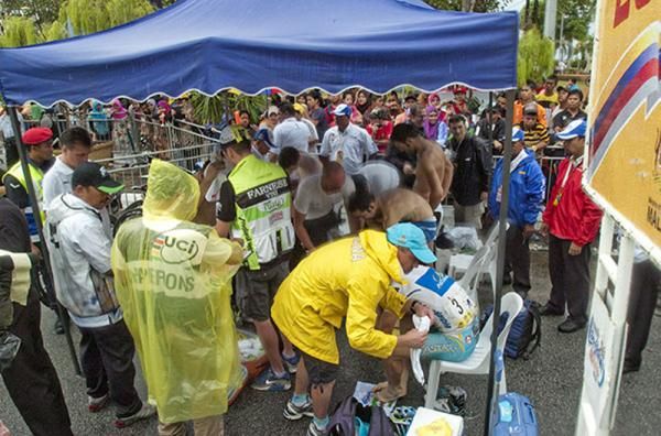 Podium riders and support staff crowd the presentation marquee in Kuala Terengganu after a rain soaked penultimate stage of the tour.