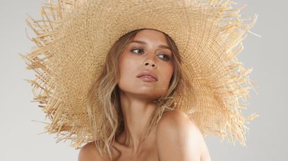 model wearing brown eyeliner and a straw hat