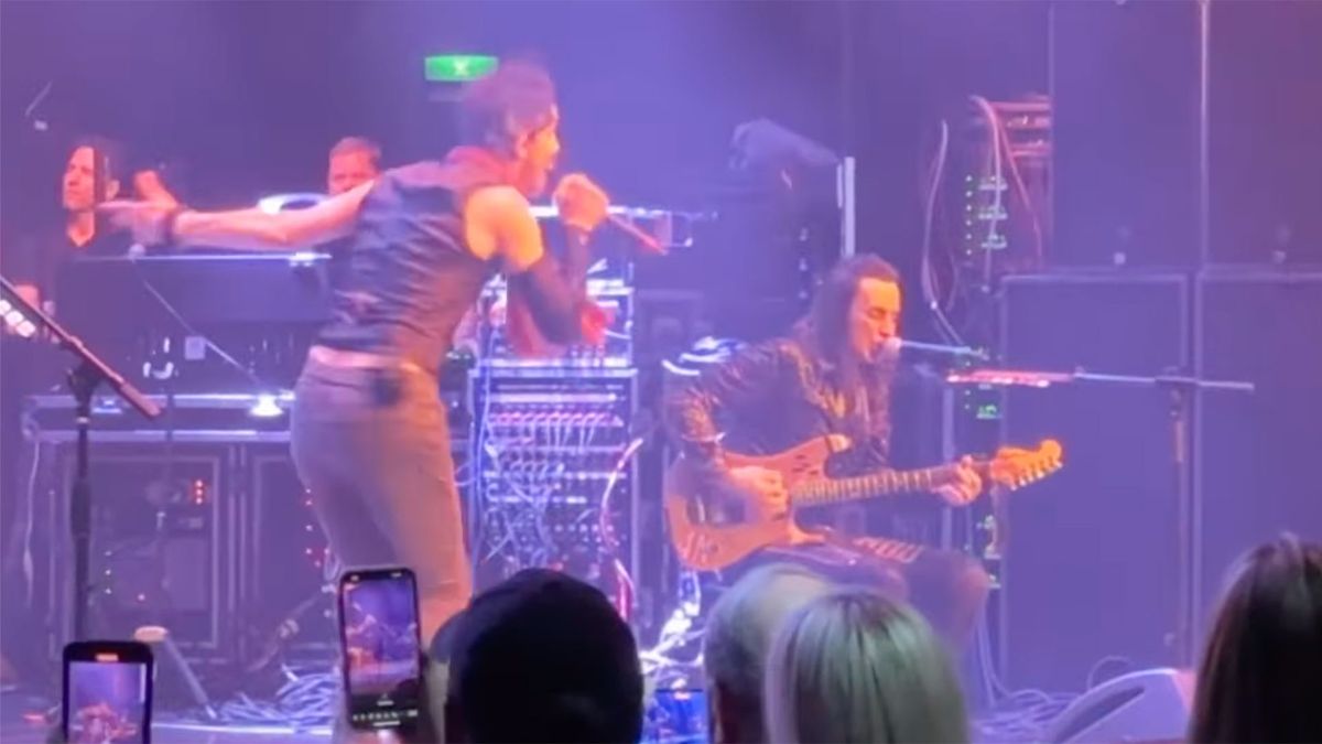 Nuno Bettencourt performs sitting down after busting his knee on