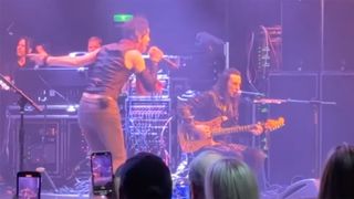 Nuno Bettencourt performs seated after sustaining a leg injury