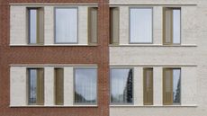 The exterior of an apartment building with anthracite windows and contrasting wall colors on either side