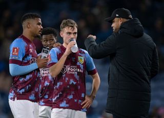 Burnley manager Vincent Kompany talks to Scott twine and Lyle Foster of Burnley during the Emirates FA Cup Fourth Round Replay match between Burnley FC and Ipswich Town FC at Turf Moor on February 7, 2023 in Burnley, England