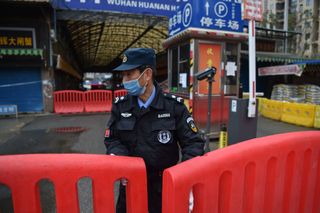 In a Jan. 24 image, a police officer stood guard outside of Huanan Seafood Wholesale Market, where some reports suggested the pandemic began.