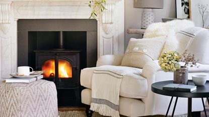 White living room with fireplace, armchair and foorstool
