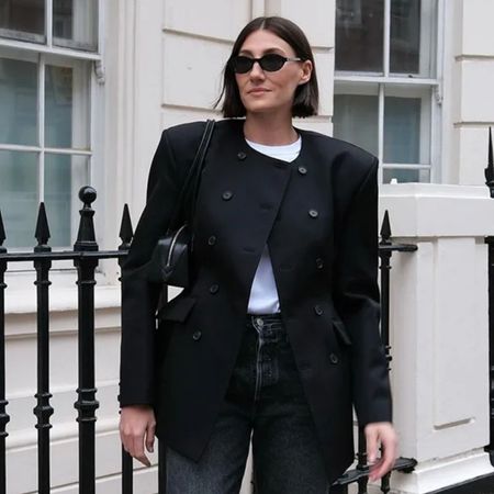 A woman wears skinny jeans with an oversized black blazer