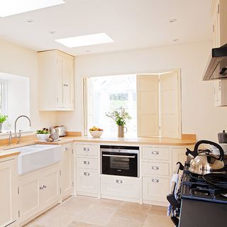 kitchen area with white wall and white cabinet with wooden counter