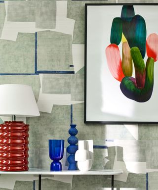 console table with sculptural light and patterned wallpaper