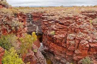 Banded iron formations (such as the one pictured at ceter at Karijini National Park, Western Australia) may come in part from iron metabolized by microorganisms