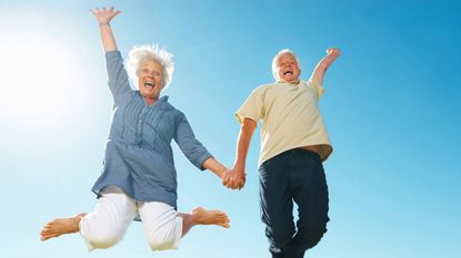 A retired couple jump for joy.