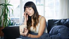 woman looking tired sitting on sofa