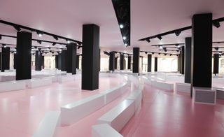 Producers Bureau Betak juxtaposed the soft pink flooring with thick black pillars and clean white benches