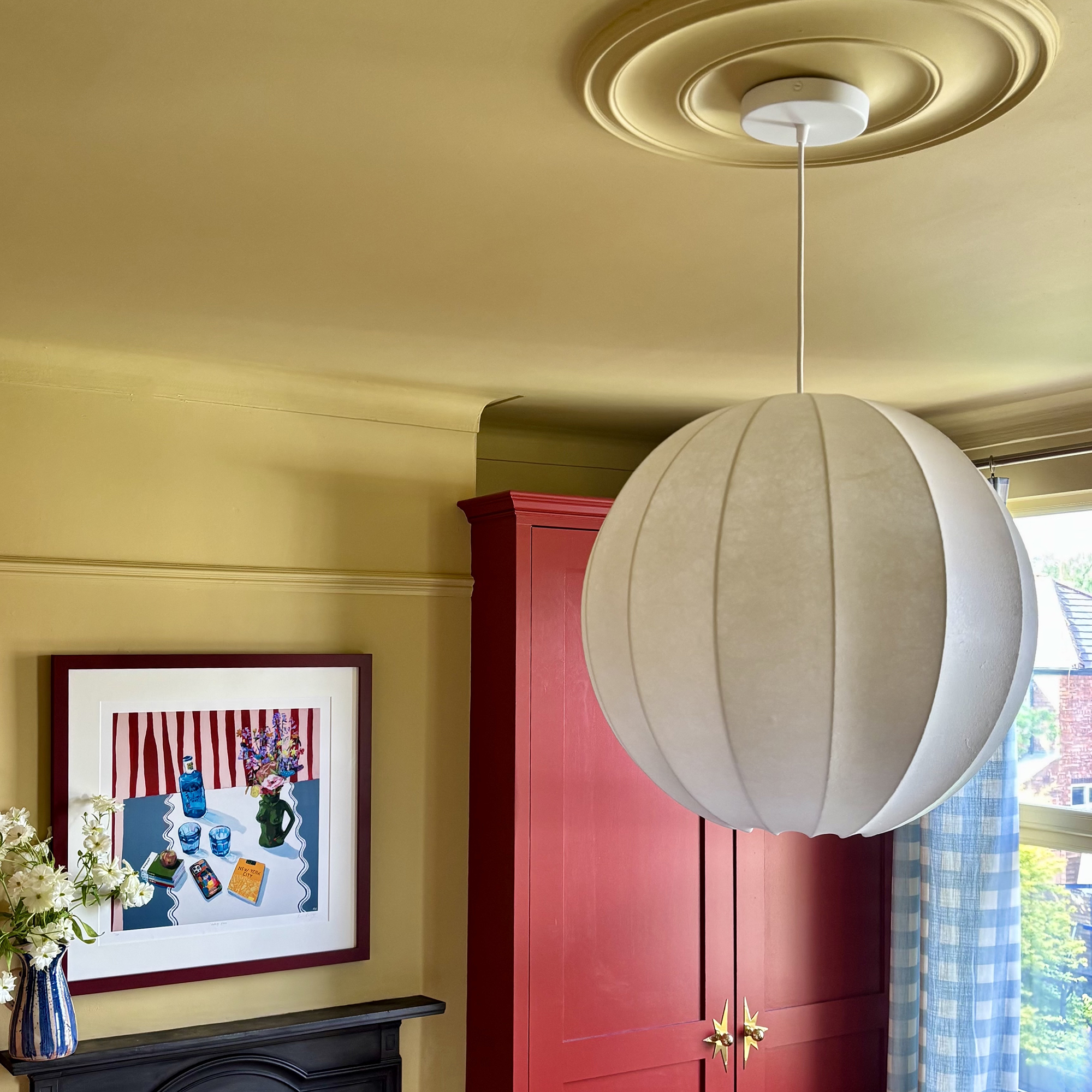 yellow ceiling with orb-shaped pendant light