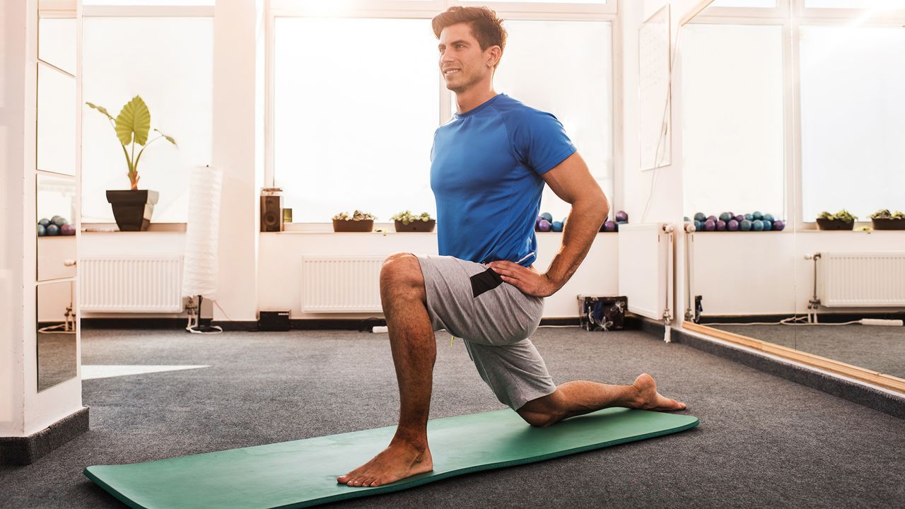 Happy man doing stretching exercises in a health club