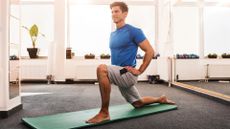 Happy man doing stretching exercises in a health club