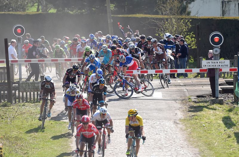 Riders try and squeeze under the barriers before the 320km/h SNCF train flies past