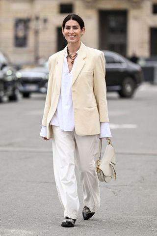 Woman in butter yellow blazer and cream trousers GettyImages-2044298186