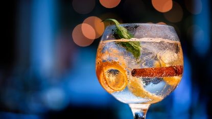 Glass of gin on bar counter with blurred background in shades of blue and boke. - stock photo