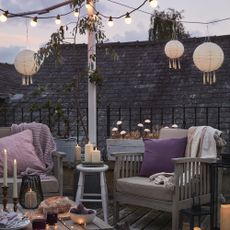 Roof terrace covered with faux candles, lanterns and festoon lighting