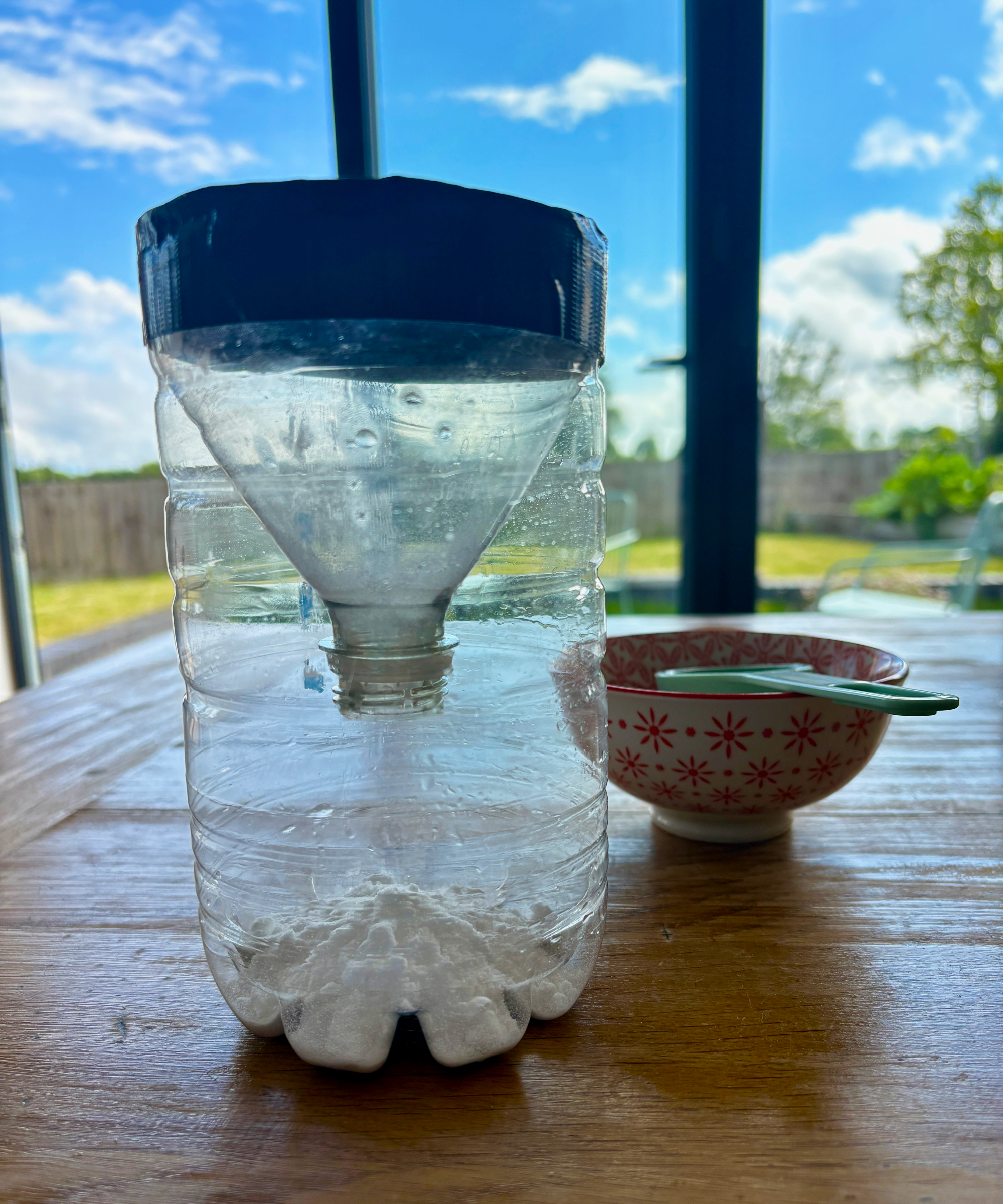 making a mosquito trap by upcycling a plastic bottle, baking soda added to the trap
