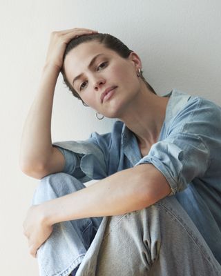 Cameron Russell sits in front of a blank wall