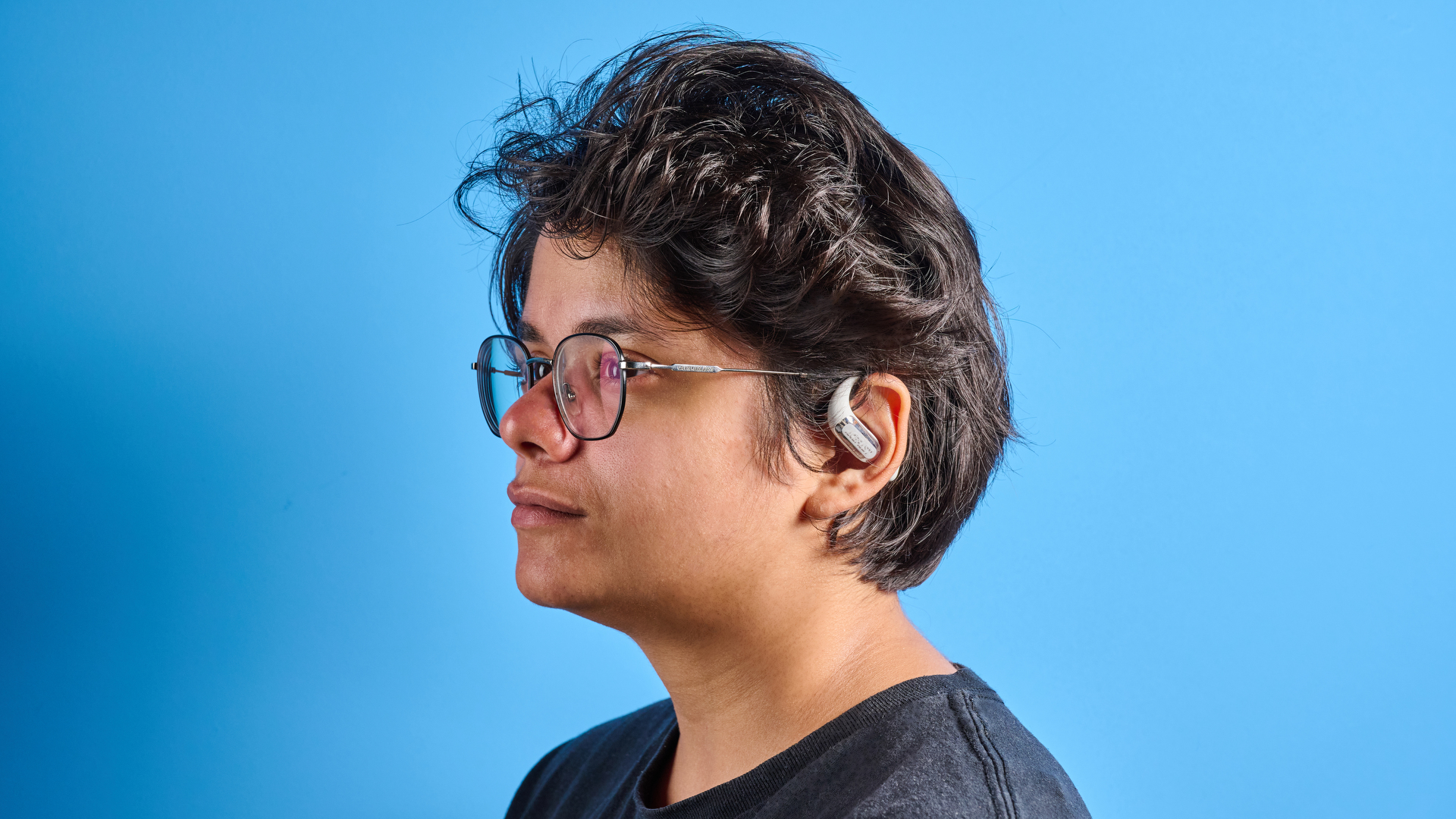 AceFast AceFit Pro open earbuds and the light up charging case photographed in front of a blue background.