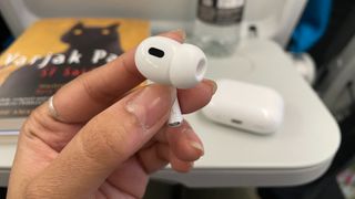 A single Apple AirPods Pro 2 earbud being held in hand.
