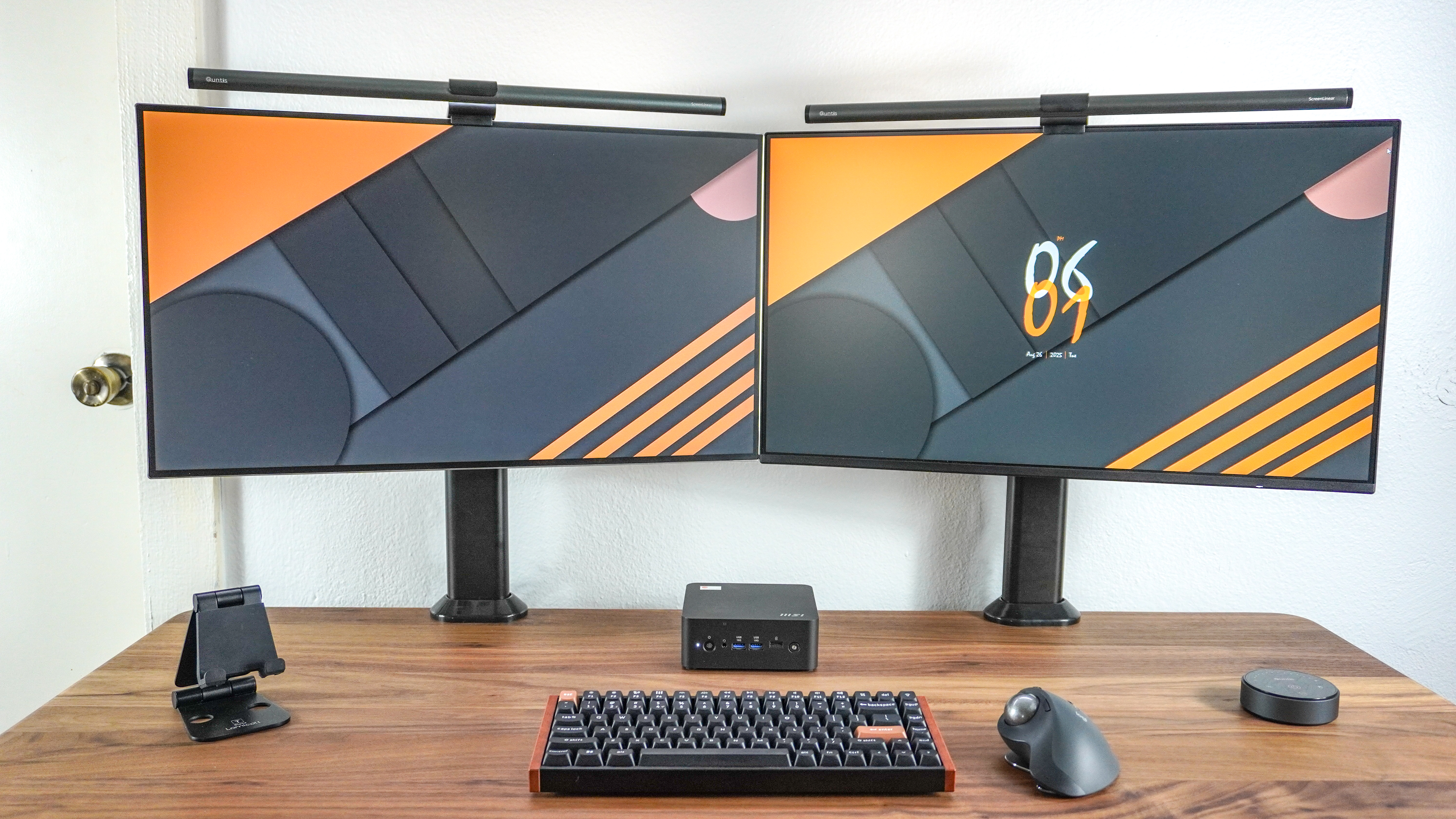 A dual-monitor setup built around the MSI Cubi NUC AI+ 2MG with the mini PC between the two displays