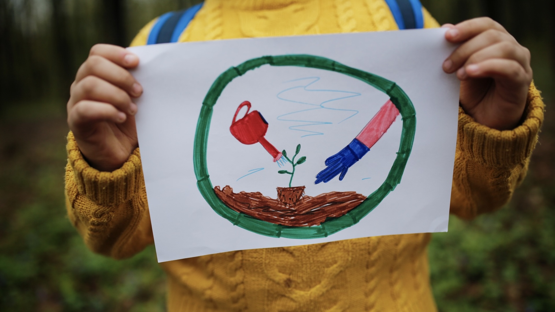 child with drawing of a growing plant