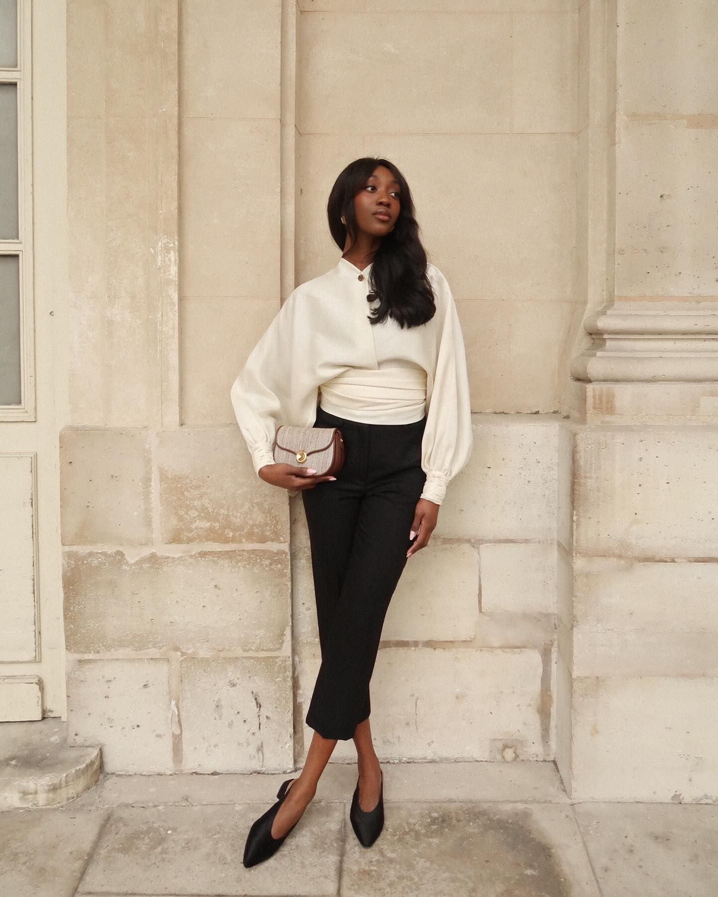 Woman in white top, capri pants, and black flats