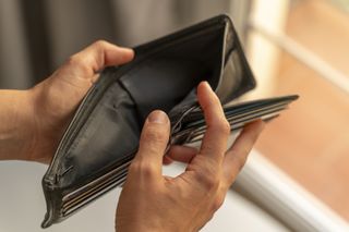 A person holding an empty wallet open.