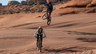 Two mountain bikers riding through the desert