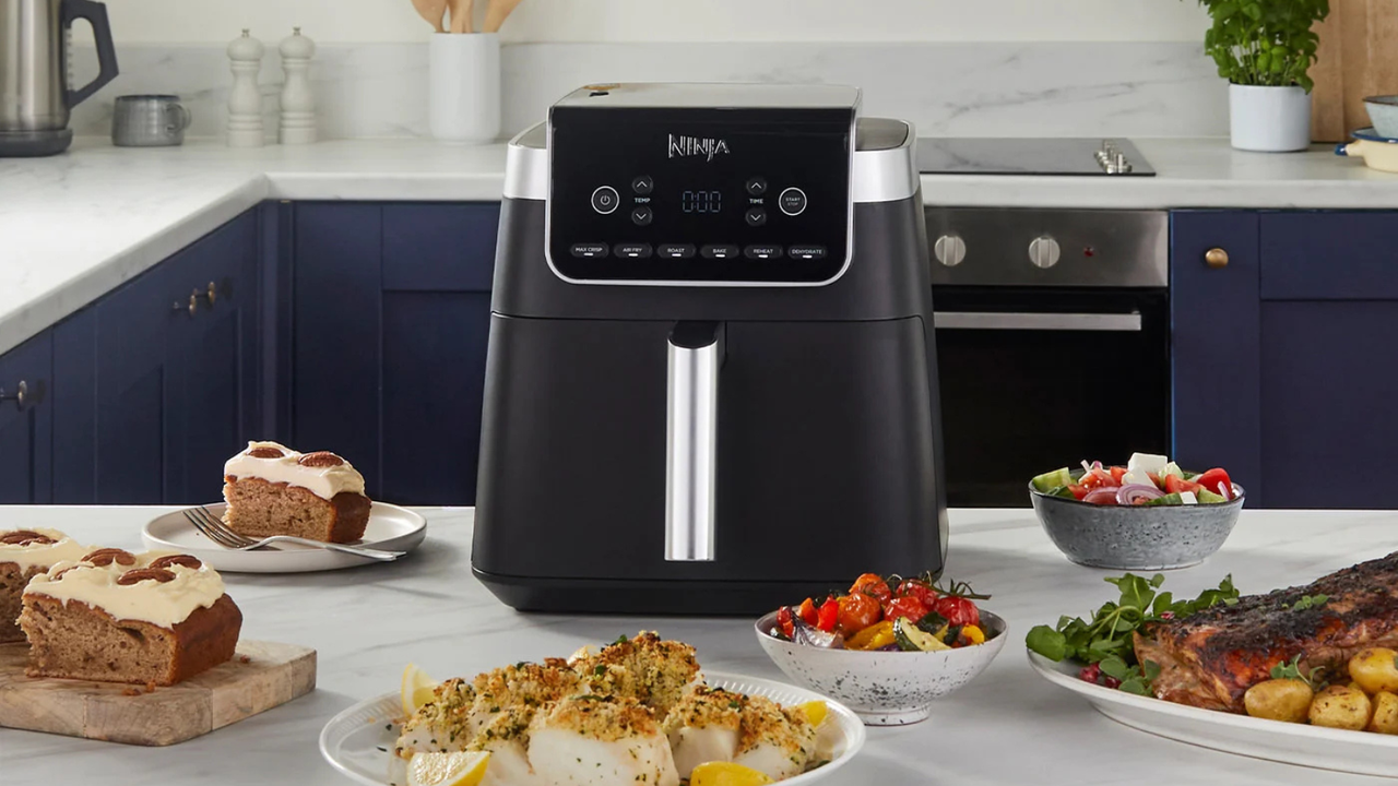 Ninja Air Fryer Pro in a navy blue kitchen, surrounded by healthy dishes