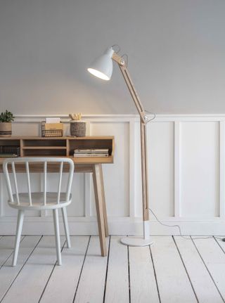 minimal office with white and gray interiors scheme, with a wooden desk and floor lamp