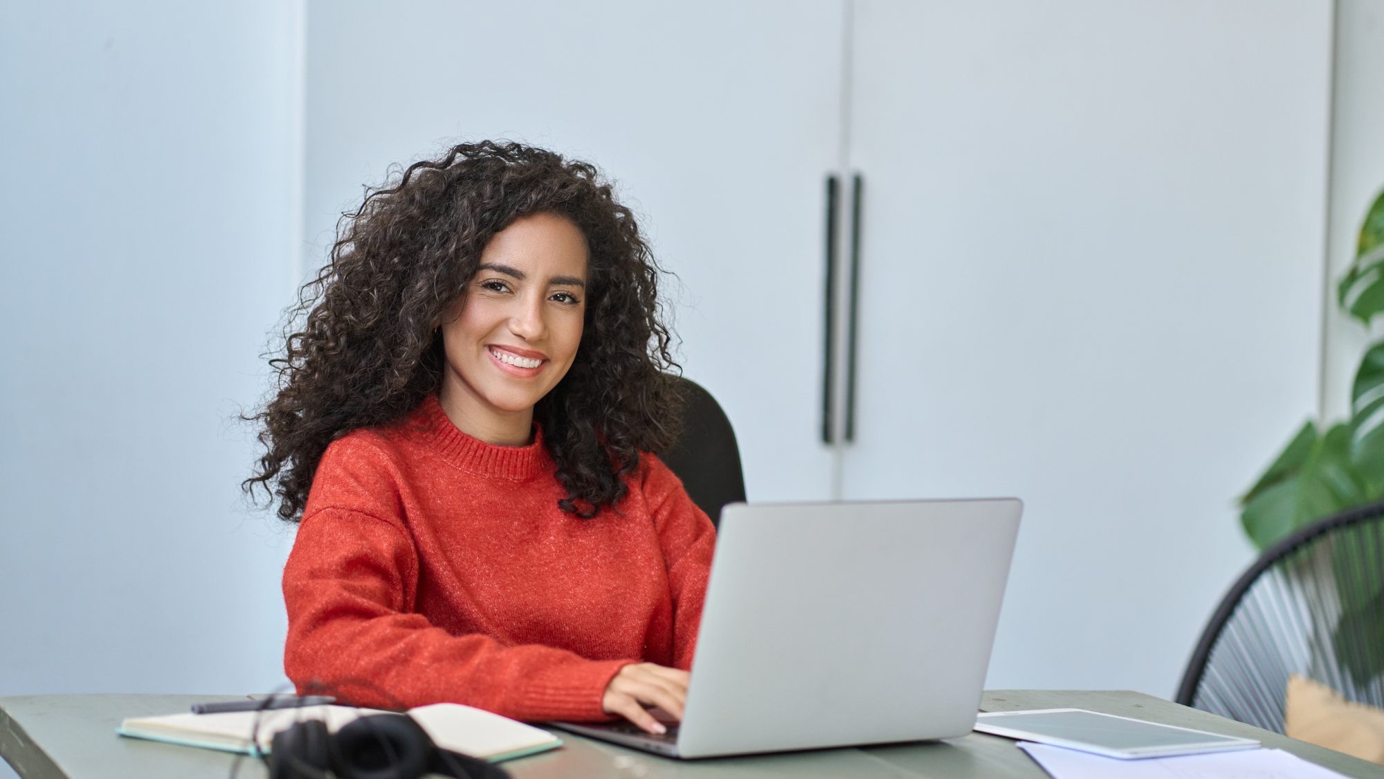 Woman in red jumper using laptop