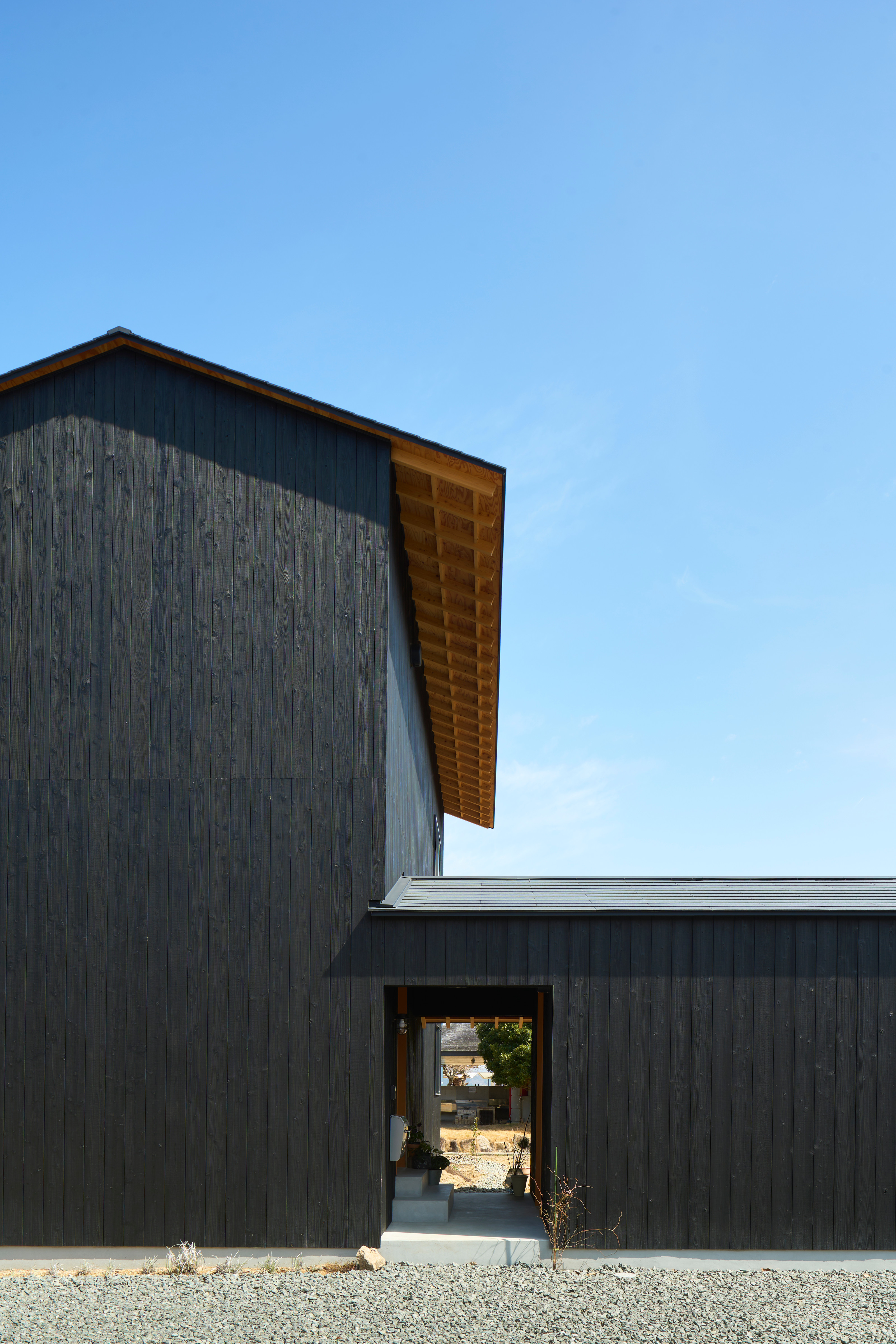 The raised main house is separated from the studio by a covered Doma