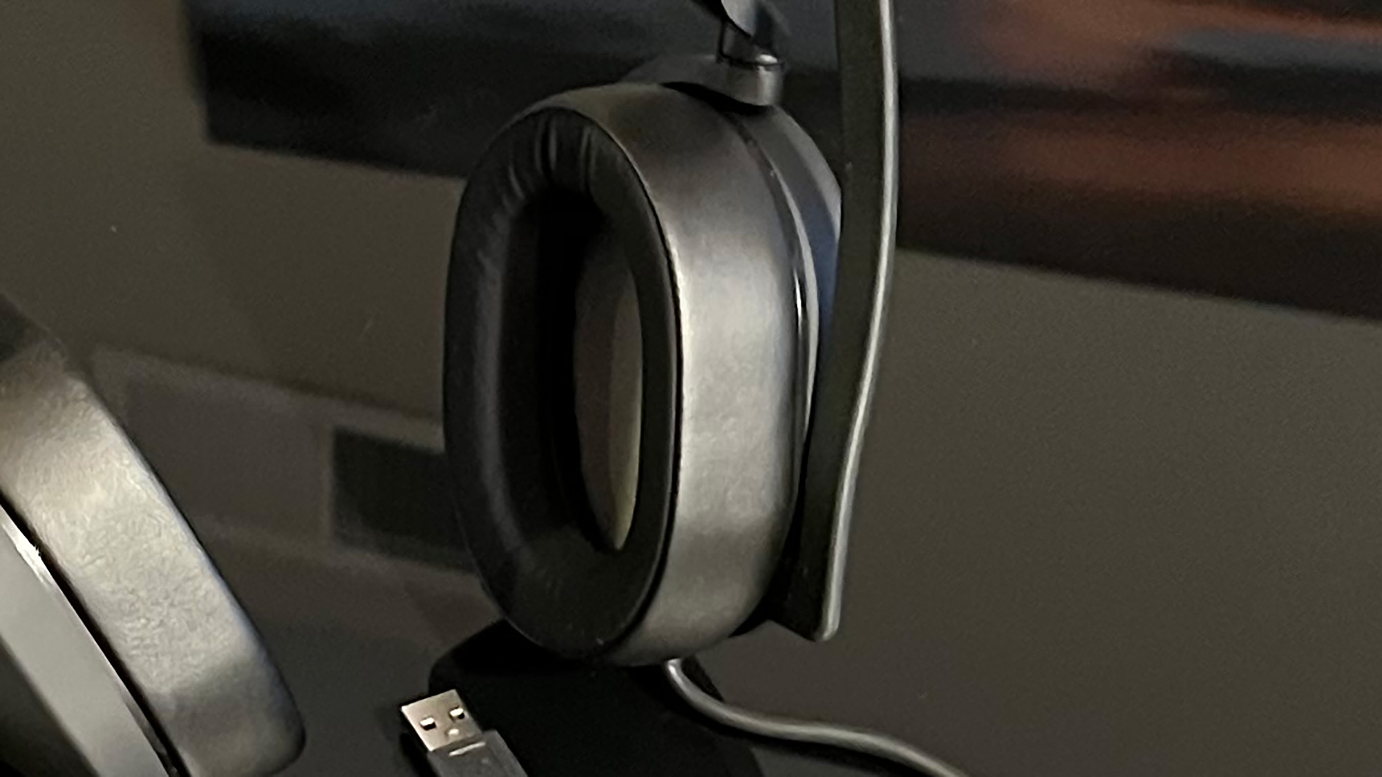 Um Corsair HS65 Surround em uma mesa preta reflexiva