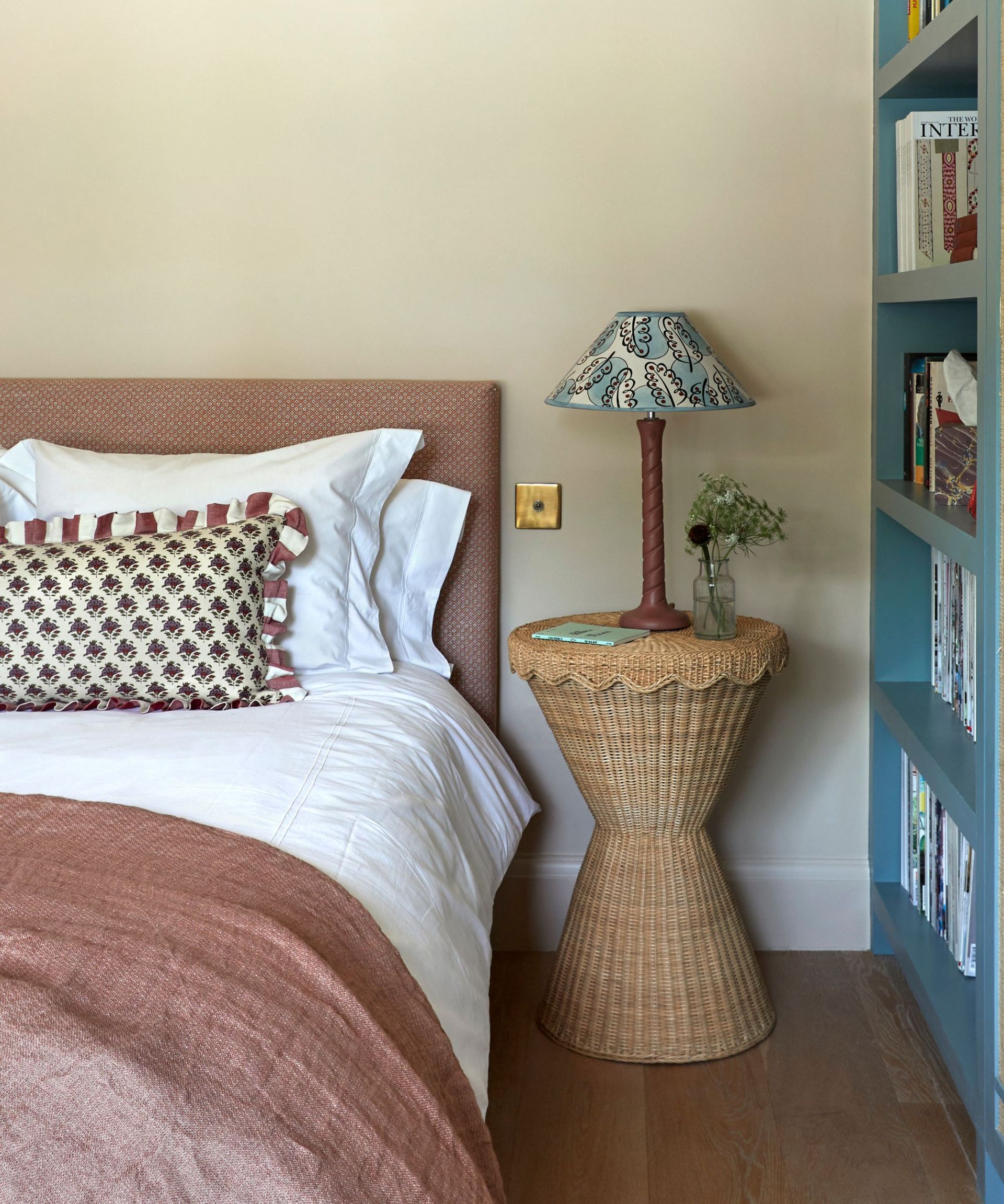 cozy bedroom with rattan side table and bedside shelving