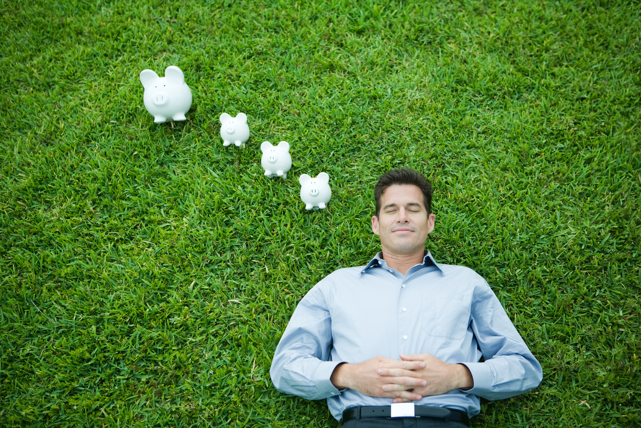 a man laying in the grass dreaming of growing his money