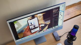 One of the best 4K monitors for Mac 2022 pictured on a desk with a microphone