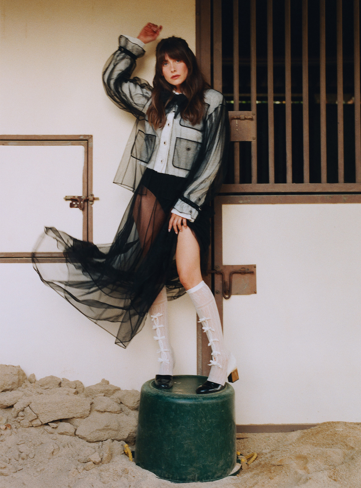 Alison Brie stands on a bucket wearing a full Chanel outfit