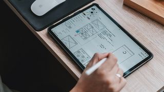 A designer using one of the best wireframe tools on a tablet