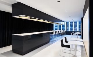 A shiny black centrepiece in the form of a long glowing table appears in the reception area