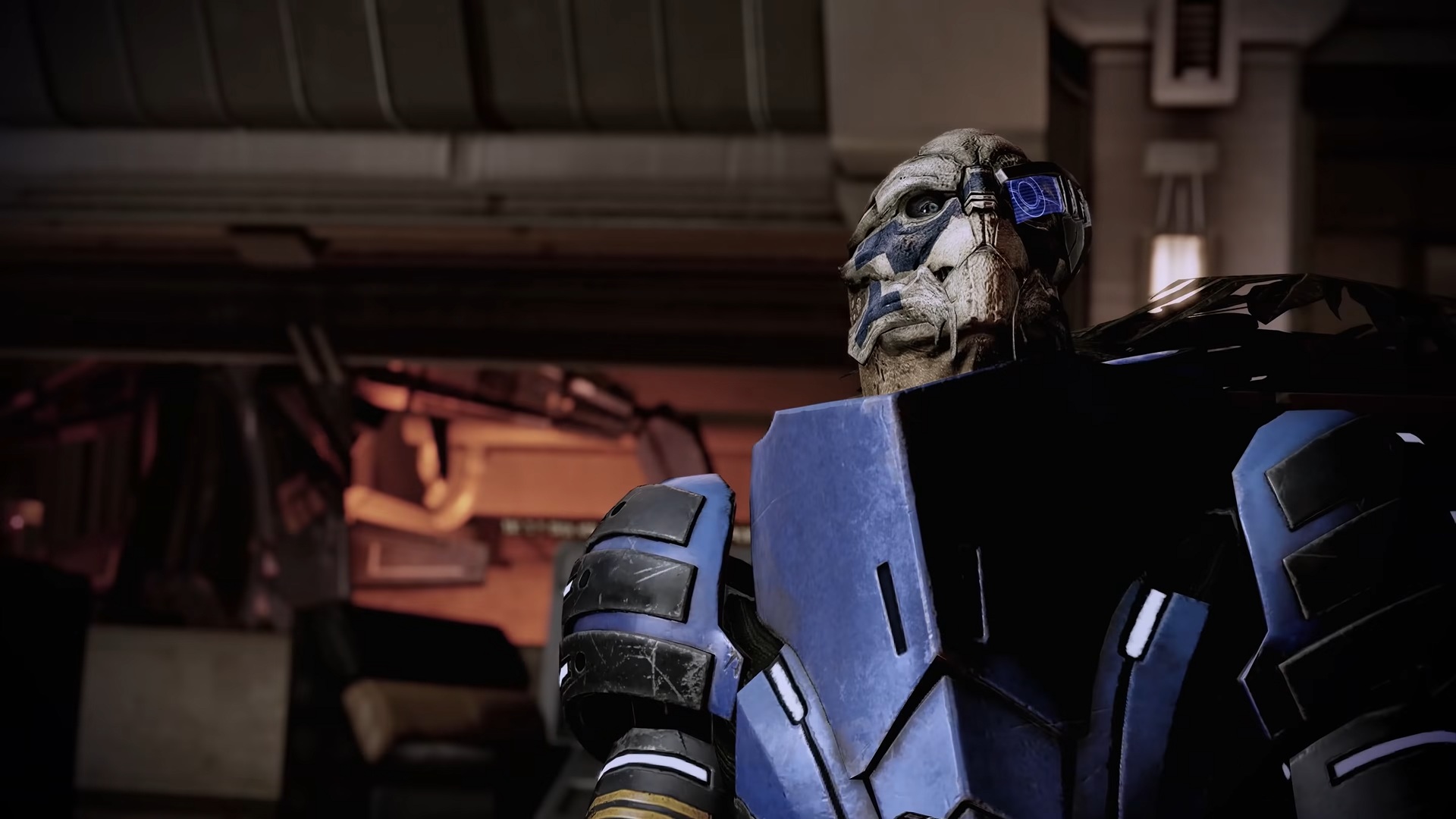 Mass Effect Legendary Edition trailer screenshot showing Garrus Vakarian taking cover behind a desk in Mass Effect 2